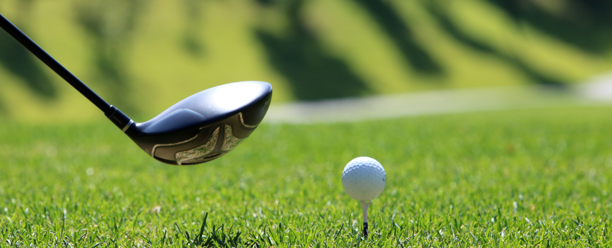 Image of golf club and golf ball on a tee