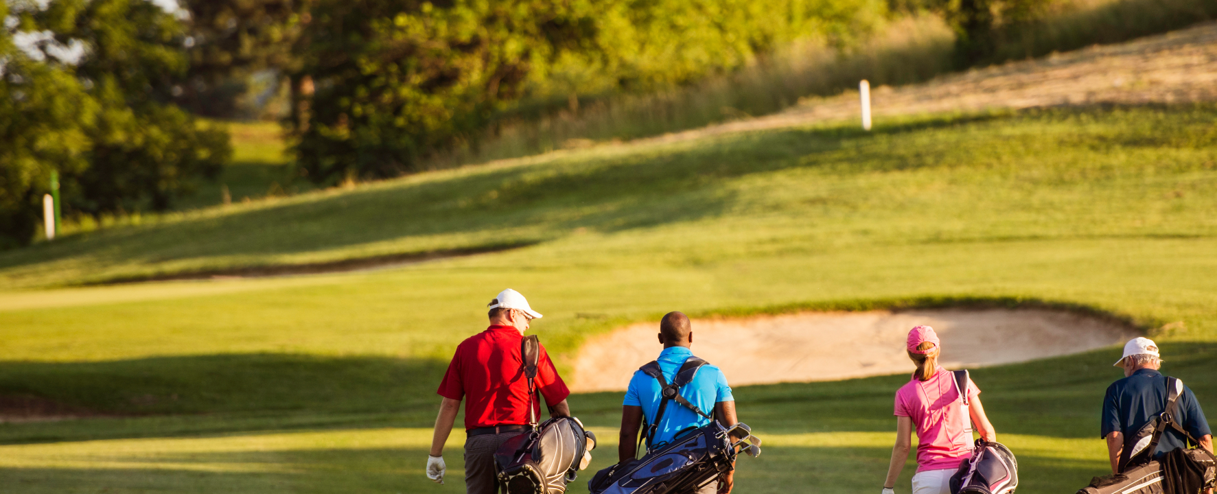Image of four adults walking on a golf course